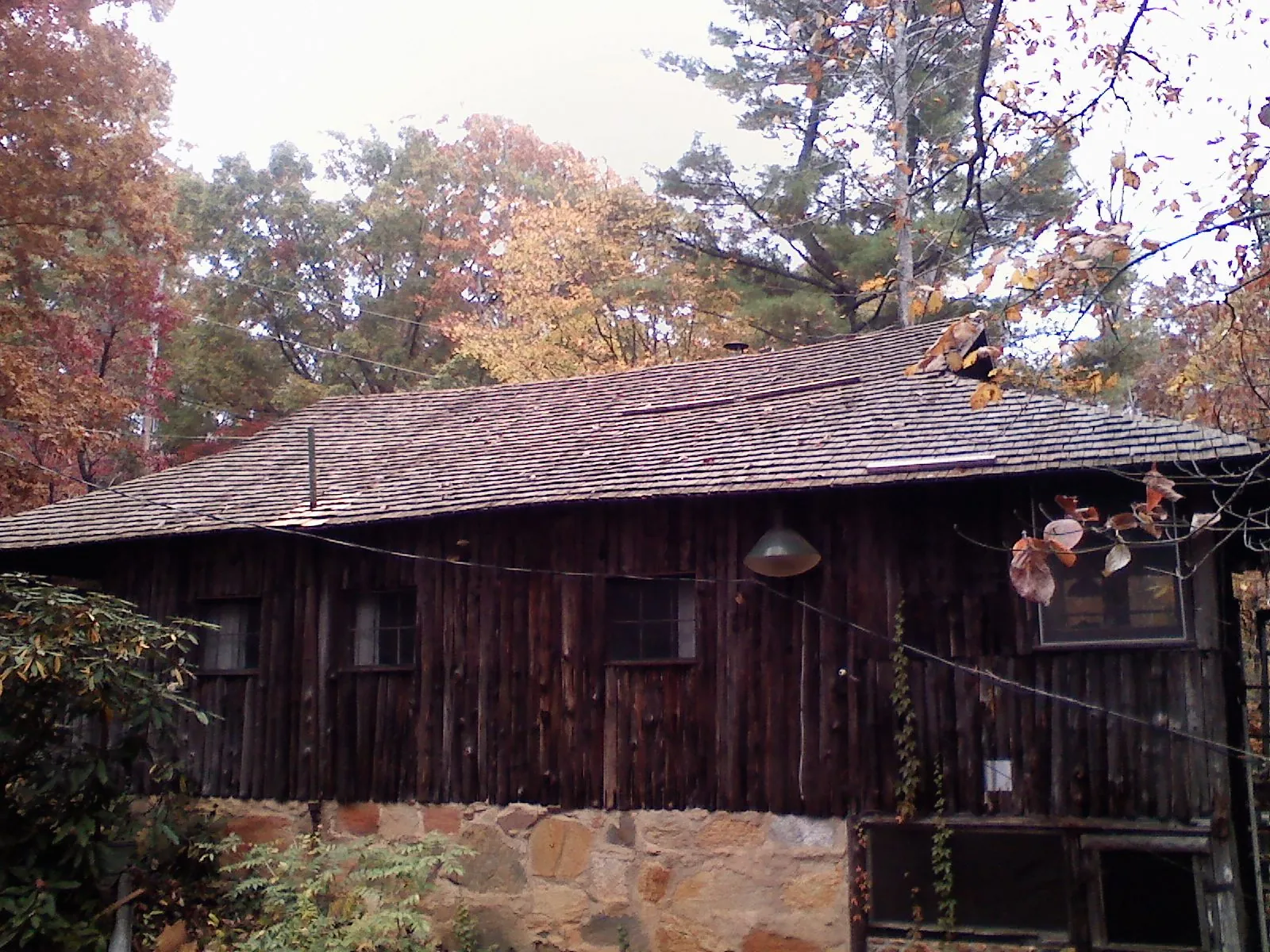 Weathered wood shake roof on a rustic board sided cabin in Grimesland