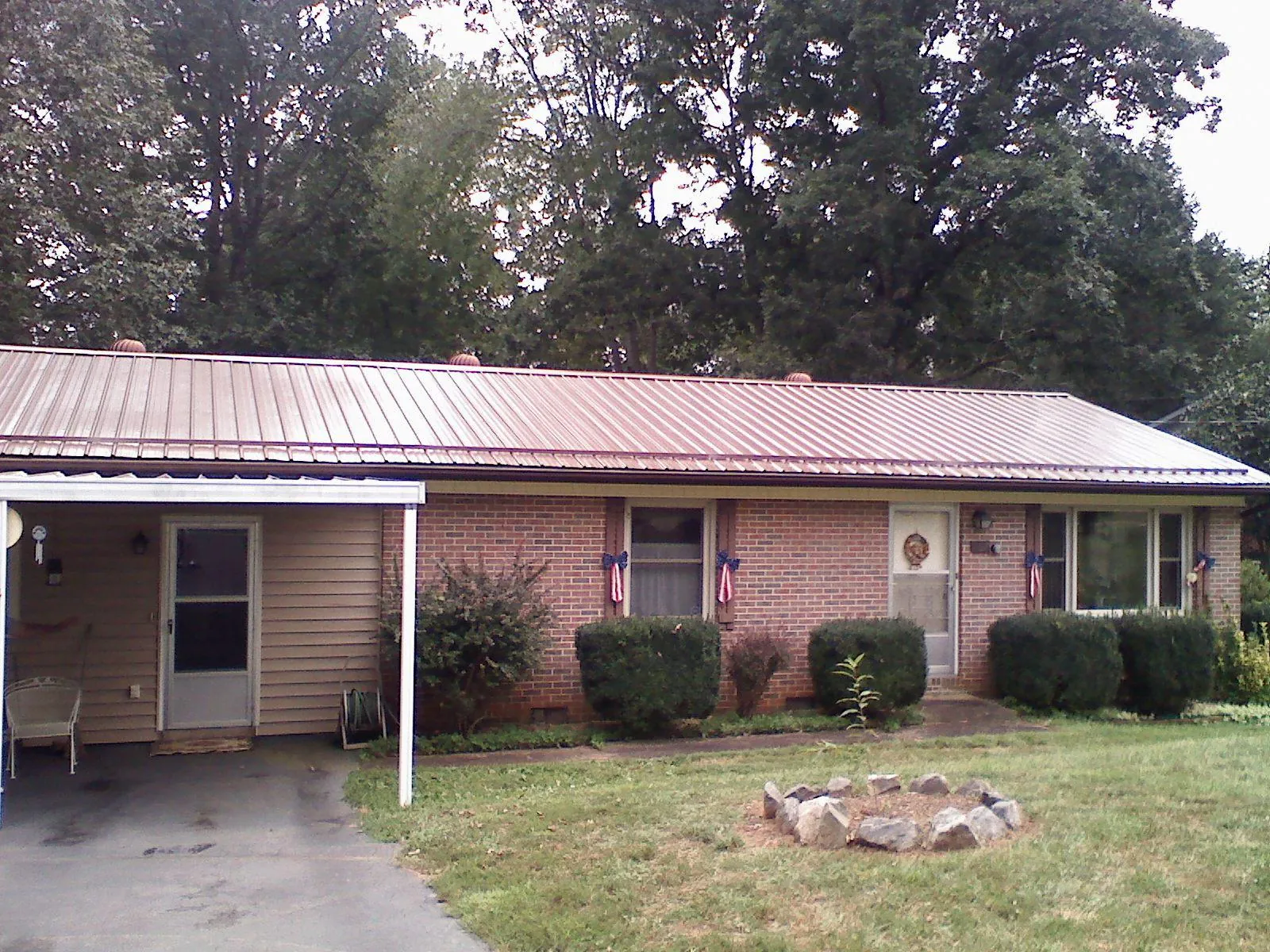 Bronze metal roof and carport on a brick ranch home — Roof Repair work by our crew in Grimesland
